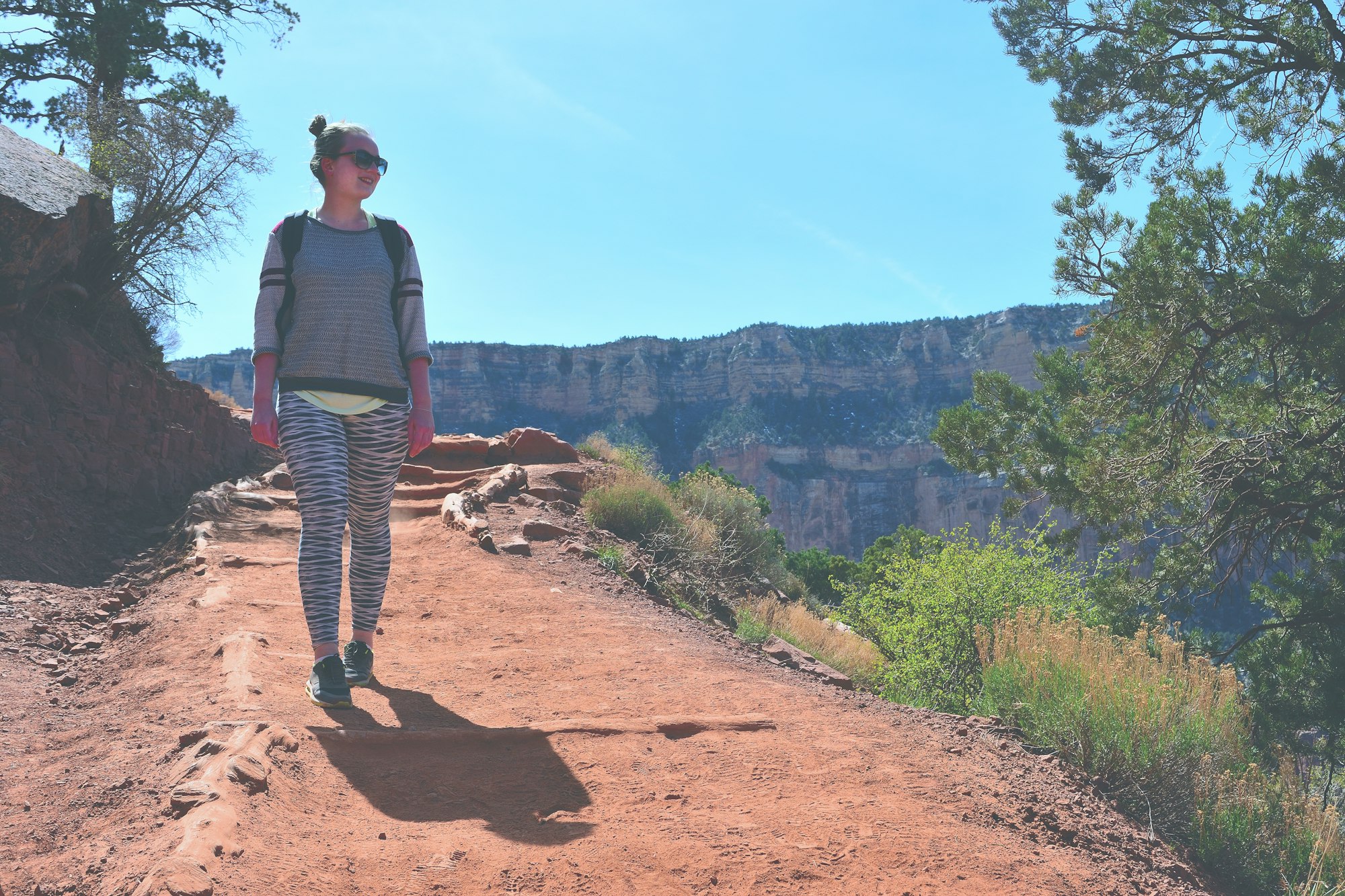 Woman walking on the path in the Grand Canyon in Arizona, a long hike in the sun